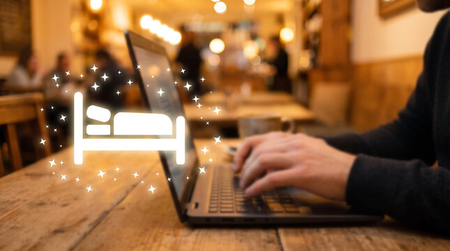Hand Typing on Laptop with Glowing Bed Icon Hotel and Accommodation Booking Concept
