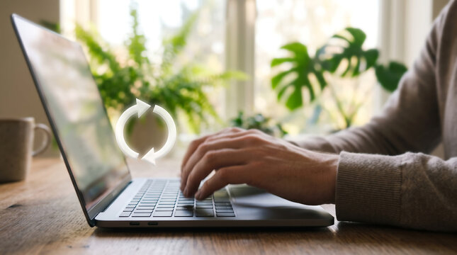Hand Typing on Laptop in Bright Greenery-Filled Home Workspace

