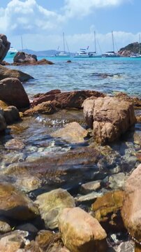 Vertical view of the turquoise bay with yachts and boats off the coast of Santa Maria Island in the La Maddalena archipelago, Sardinia, Italy