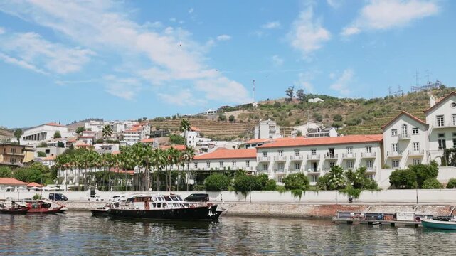 Views of Douro River in Portugal with boats and hills under blue sky
