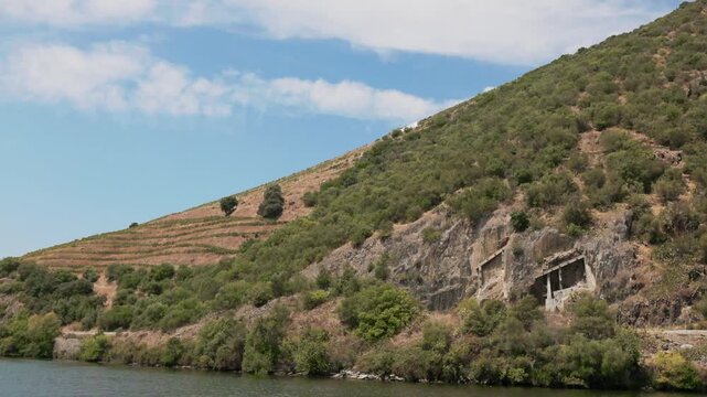 Exploring the natural landscape along the Douro River in Portugal with green hills and riverside views