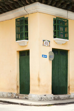 Colonial building corner on Calle de los Oficios with green doors and windows in Havana Cuba