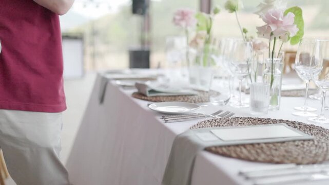Waiter preparing elegant table setting for wedding