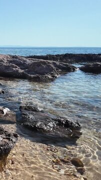 Rocky coastline and crystal clear waters on the Aegean Sea on the island of Thasos, Greece. Vertical view.