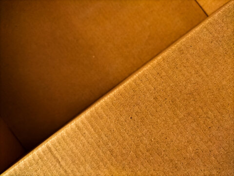 Close-up shot of the edge and interior of an open brown cardboard box.