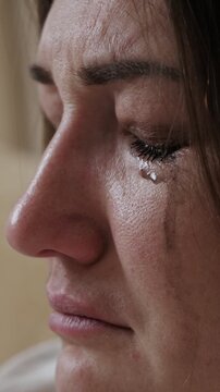 Profile shot capturing the intense emotional moment of a heartbroken woman crying, with tears mixed with running mascara streaming down her face, conveying feelings of despair, grief, and sorrow