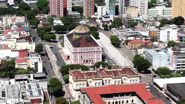 Breathtaking aerial video circling the iconic pink Amazon Theatre building surrounded by the urban cityscape of Manaus.