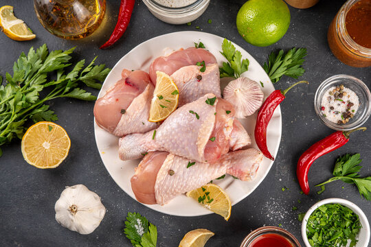 Fresh raw organic chicken legs, drumsticks, with spices and condiments