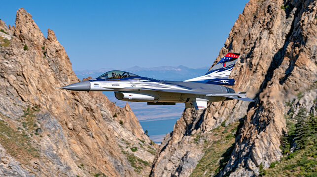 F16 fighter jet flying through a narrow mountain valley, aircraft banking between dramatic rocky peaks, atmospheric morning haze and natural sunlight, cinematic wide landscape composition, realistic