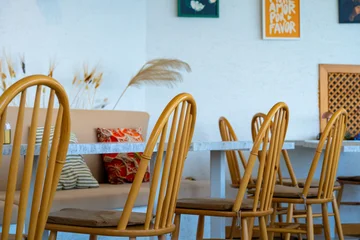 Fotobehang Horeca Cozy Modern Cafe Interior with Wooden Windsor Chairs, Marble Tables, and Cushioned Seating  © fencifd