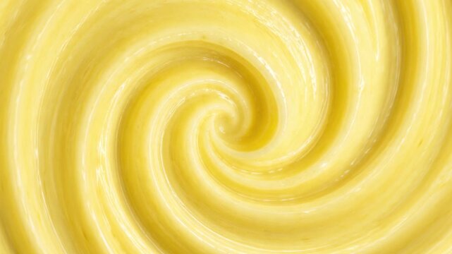 Abstract swirling spiral pattern of smooth yellow butter, lemon curd, or cosmetics background Top view macro swirl texture of creamy yellow custard or mayonnaise with video play button