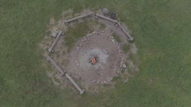 Vertical rotating ascent over campfire and log seats, D-Log