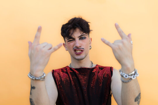 Young person expressing individuality with rock hand gestures