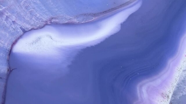 Mixing alcohol inks and epoxy resin in a close-up view of colored patterns