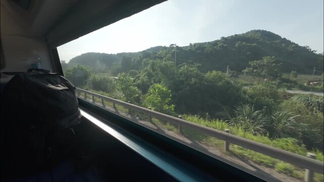 Daytime view of rural Vietnam from a sleeper bus window, passing green fields, villages, houses, and countryside scenery along the road with backpack