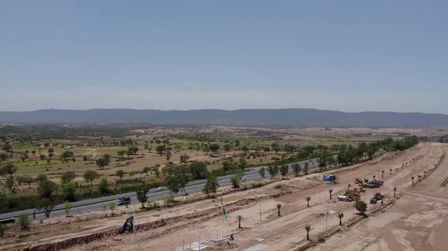 Road construction crosses dry rural terrain along the M2 near Kalar Kahar, Punjab, Pakistan