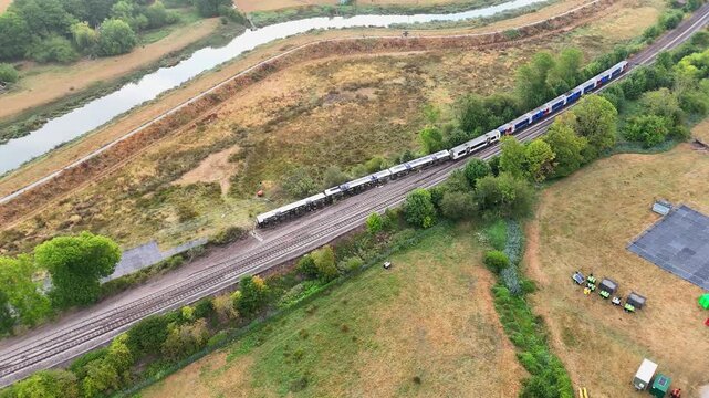 Drone footage shows three overturned carriages from a London Victoria to Eastbourne passenger service following a major derailment. Lewes, East Sussex, United Kingdom, August 2026