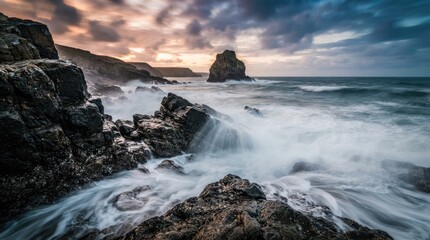 Fototapeta premium Rugged Rocky Seashore with Powerful Ocean Waves and Dramatic Sunset Clouds