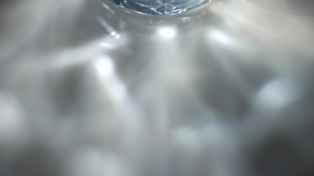Glass rim casts soft blue reflections and caustic light patterns across a dark surface. Concept abstract optics for ads, websites, banners, magazines and presentations.