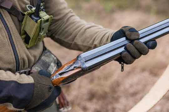 Hunter handling shotgun, reloading in preparation for hunting