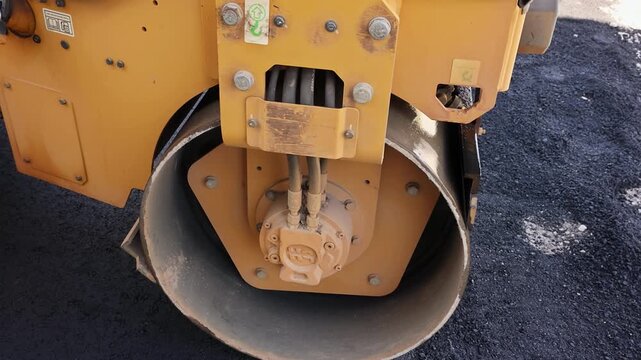 Steamroller is working on road to compact fresh asphalt at construction site
