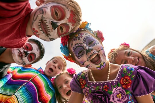 Portrait of children with sugar skull face paint during day of the dead celebration. Smiling Children in Colorful Sugar Skull Makeup Celebrating Day of the Dead