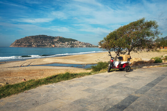 Scenic View of Alanya Cleopatra Beach and Castle Hill with Delivery Scooter