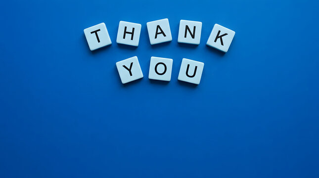 Thank you message spelled out with white letter tiles on a vibrant blue background
