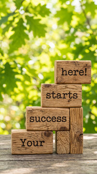 Wooden blocks stacked to form steps, spelling "Your success starts here!", symbolizing growth and achievement against a blurred green leafy background