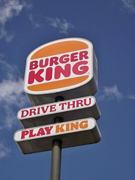 Burger King sign showing drive thru and play king options under blue sky