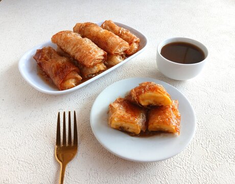 Golden crispy Banana Turon, a traditional Filipino snack made with sweet banana wrapped in a thin spring roll wrapper and fried until golden brown, served with caramelized syr