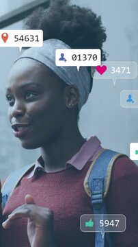 Animation of icons and data processing over african american woman using smartphone