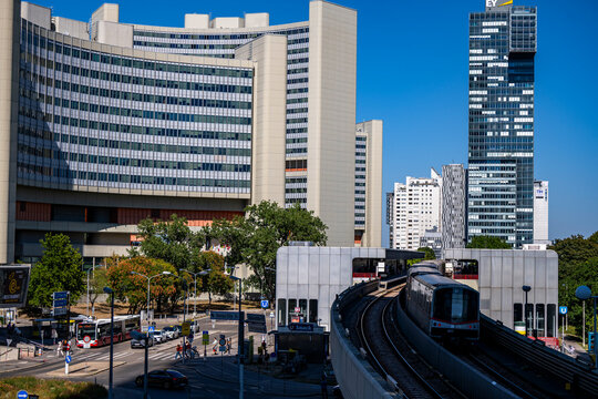Vienna, Austria - August 14, 2026: U-Bahn train approaching Kaisermuehlen station with Vienna International Centre and modern skyscrapers in Donau City.