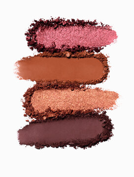 Close up of crushed range of eye shadows isolated on white background. Eyeshadow product compositon sample swatches