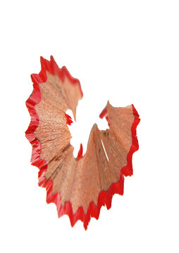 Red pencil shavings on a white background. Curved wood shavings from pencil sharpening. The concept of drawing, education, and school supplies.