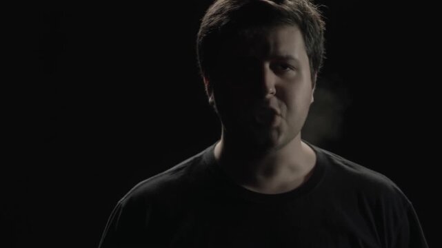 Man Speaking Directly to Viewer in Dramatic LowKey Lighting Against Black Background