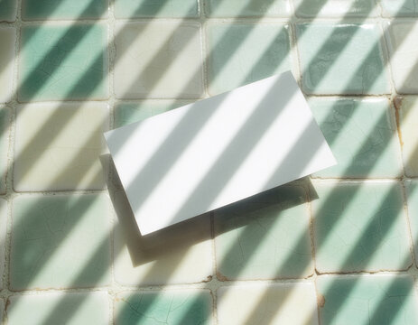 Blank white business card mockup template on vintage green tiles