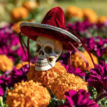 Marigolds and a skull with a sombrero decorate a grave during the Day of the Dead celebration