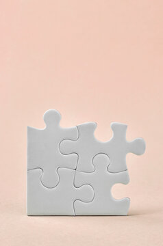 Four connected puzzle pieces on pastel background