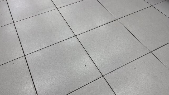 Minimalist grey ceramic floor tiles with dynamic shadows