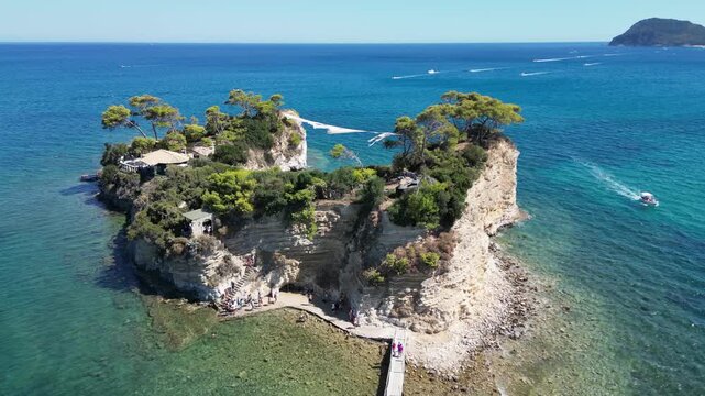 Aerial footage showcasing the rocky Cameo Islet surrounded by the blue Aegean Sea