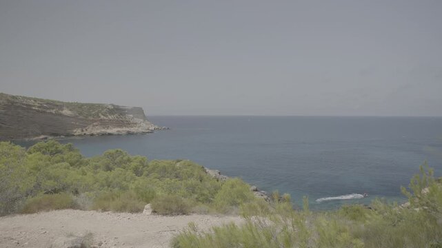 Expansive view of Ibizas coastline near Portinatx Torre with lush greenery and clear blue waters captivating scenes cinematic quality rich detail smooth motion