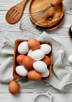mixed white and brown eggs in wooden tray