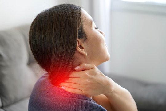 Inflamed Cervical Concept. Close Up of Woman Hand Massaging Sore Neck with Expression of Pain and Discomfort.