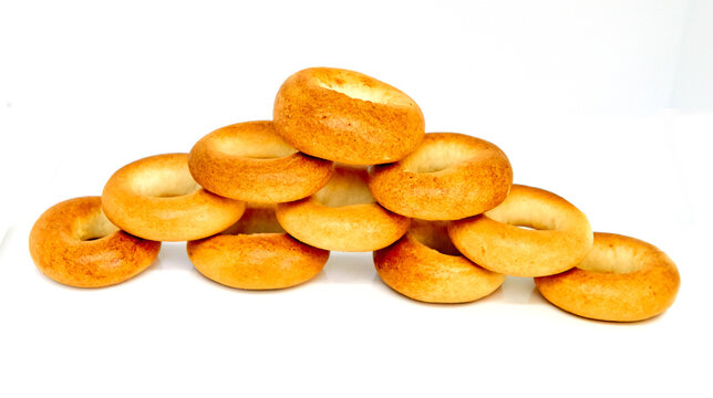 Stack of a dozen golden brown bagels in a variety of flavors. Everything Bagels Isolated on White background