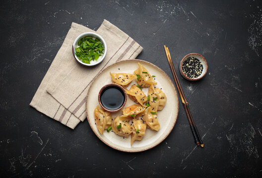 Gyoza dumplings soy sauce chopsticks asian Japanese food wontons black background