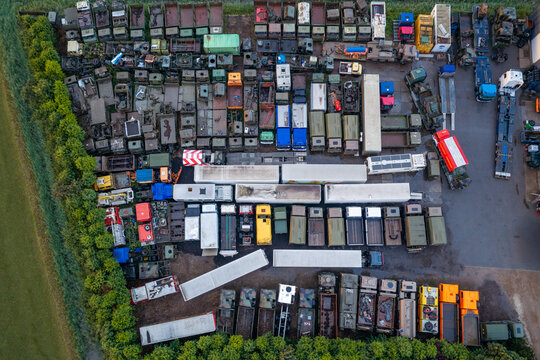 Aerial view of an assortment of old trucks and vehicle parts stored in a yard at a repair and sales facility in North Holland, Netherlands.