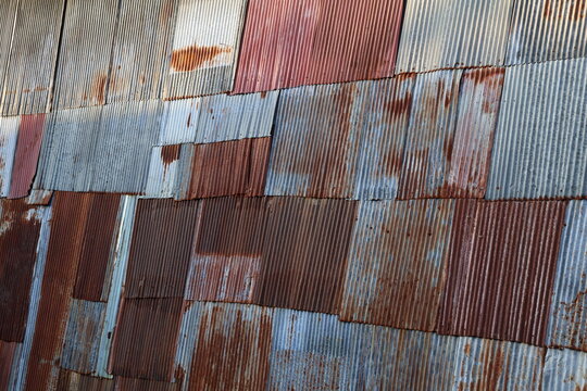 Rusty metal roof. Vintage style metal sheet roof texture. Pattern of old metal sheet. Rusting metal or siding. Corrosion of galvanized. Background and texture in retro concept