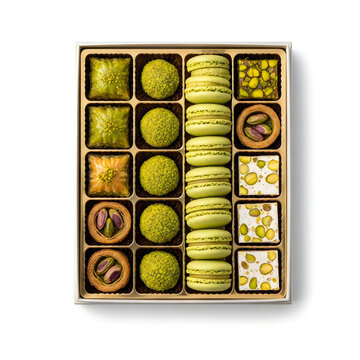 Assorted gourmet sweets and green macarons in a gift box for festive celebrations