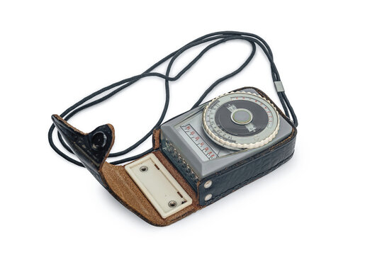 Vintage analog photographic light meter with leather case isolated on white. Measuring brightness of lighting.